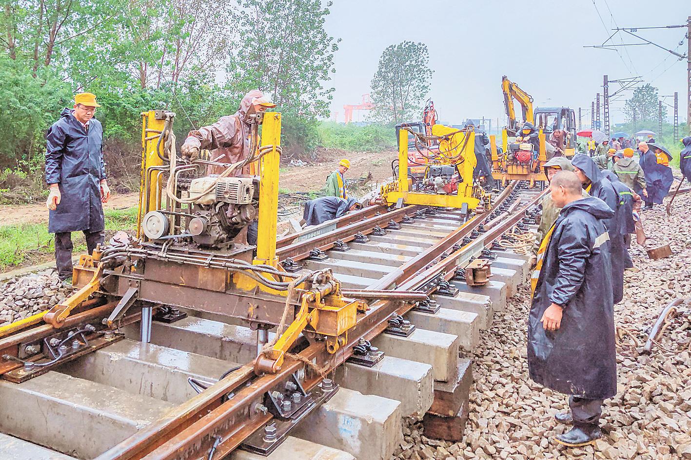 月  日,中铁七局施工人员冒着大雨进行道岔铺轨施工.